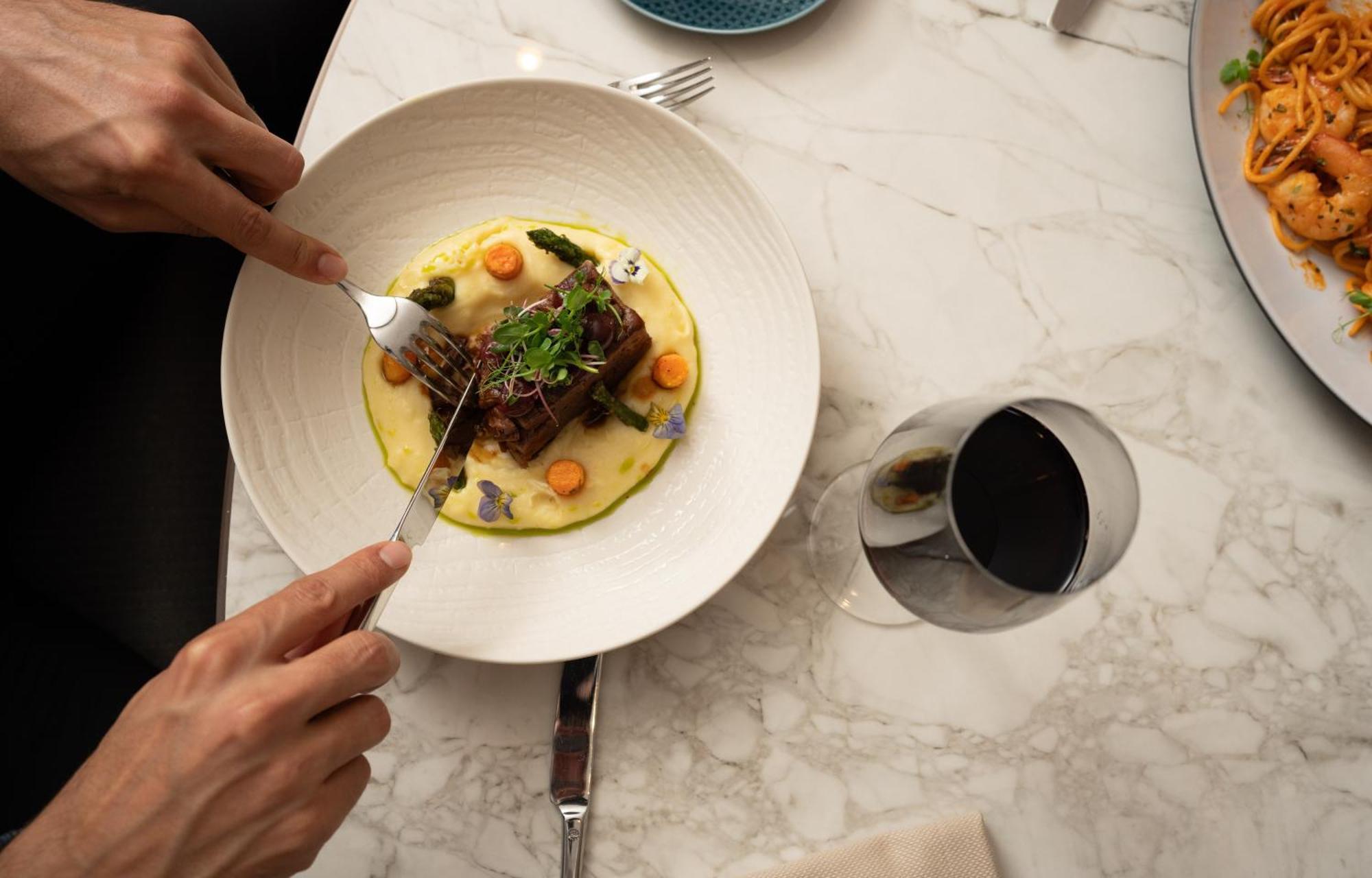 Address Istanbul Hotel Екстериор снимка A person using a fork to cut into a meal
